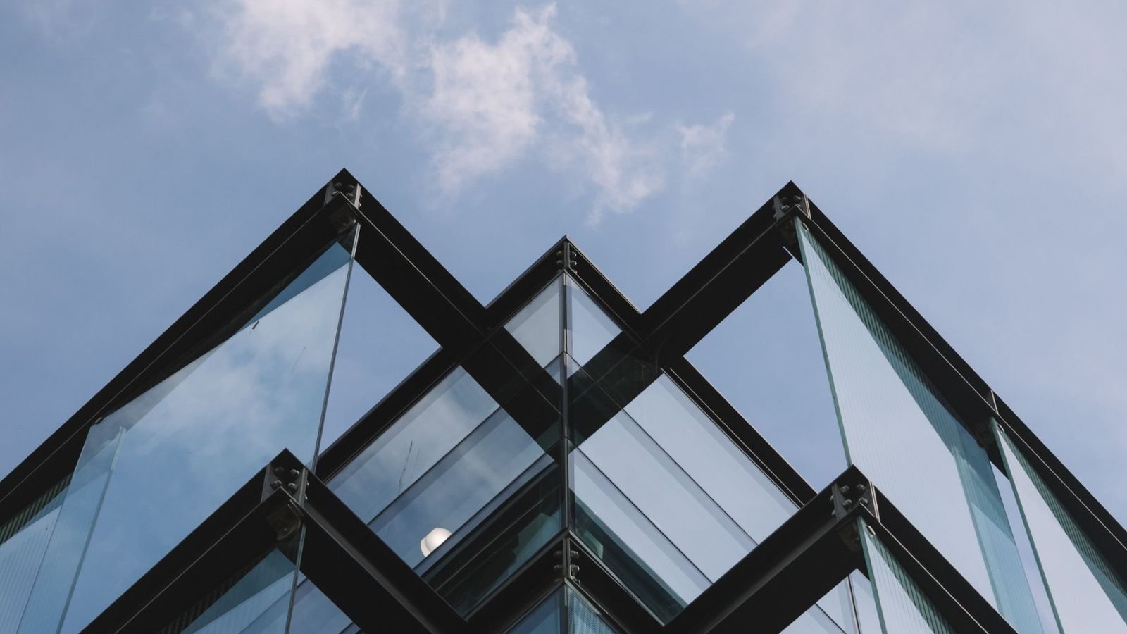 Angle d'un bâtiment de verre et d'acier vu d'en dessous, sous un ciel bleu